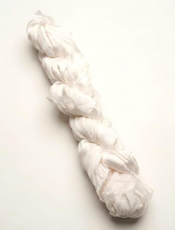 Natural ivory mulberry chiffon gauze silk ribbon coiled on a light background
